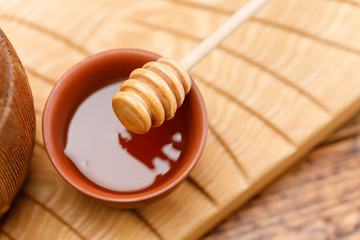 Honey spoon comb on a wooden background.