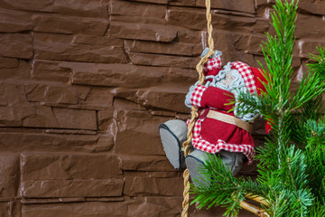 Christmas composition of a Christmas tree and Santa Claus climbing a rope
