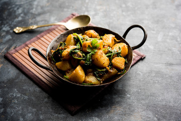 Aloo Palak sabzi - Potato cooked with spinach with added spices. a healthy Indian main course recipe. Served in a bowl, selective focus