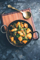 Aloo Palak sabzi - Potato cooked with spinach with added spices. a healthy Indian main course recipe. Served in a bowl, selective focus