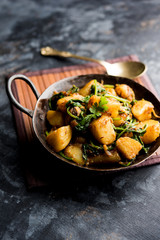 Aloo Palak sabzi - Potato cooked with spinach with added spices. a healthy Indian main course recipe. Served in a bowl, selective focus
