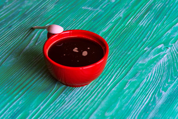 A cup of coffee on a green wooden background.