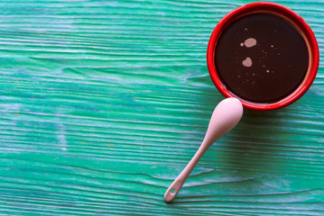 A cup of coffee on a green wooden background.