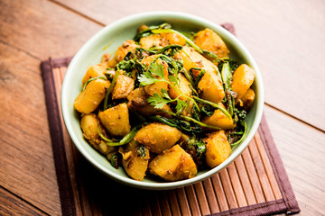 Aloo Palak sabzi - Potato cooked with spinach with added spices. a healthy Indian main course recipe. Served in a bowl, selective focus