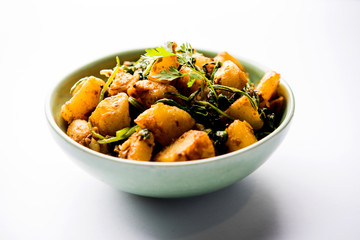 Aloo Palak sabzi - Potato cooked with spinach with added spices. a healthy Indian main course recipe. Served in a bowl, selective focus