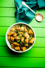 Aloo Palak sabzi - Potato cooked with spinach with added spices. a healthy Indian main course recipe. Served in a bowl, selective focus