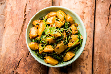 Aloo Palak sabzi - Potato cooked with spinach with added spices. a healthy Indian main course recipe. Served in a bowl, selective focus