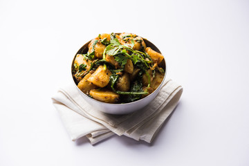 Aloo Palak sabzi - Potato cooked with spinach with added spices. a healthy Indian main course recipe. Served in a bowl, selective focus