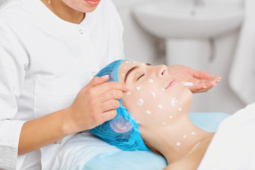 Obraz na płótnie Canvas Cosmetologist makes facial massage to a young woman.