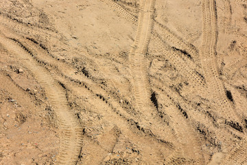 Traces of tire treads on a dry soil surface.