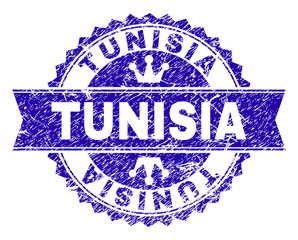 TUNISIA rosette stamp imprint with distress texture. Designed with round rosette, ribbon and small crowns. Blue vector rubber print of TUNISIA text with dust texture.