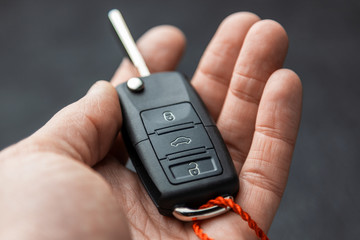 Car keys with remote control alarm system man holds in his hand.