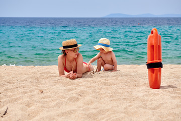 Toddler boy on beach with mother