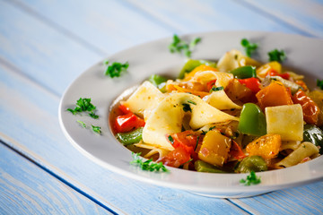 Pasta with vegetables on wooden background
