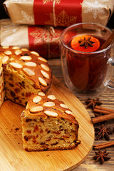 Closeup homemade cake with almonds and a mug of mulled wine on wooden table. Shallow focus.