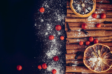 Christmas bakery and New Year concept. Holiday background with dried lemon citrus slices, set of cinnamon sticks and vanilla powder. Cosy winter holiday baking, mulled wine frame on dark background.