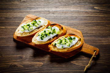 Bruschettas on cutting board on wooden background