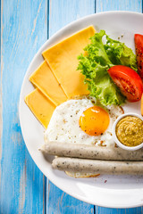 English breakfast - fried egg,sausages,bun and vegetables