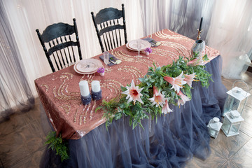 Served table with pink plates on pink tablecloths and Cutlery.