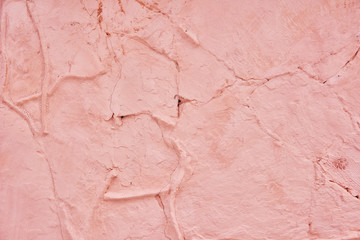 Textured background pink cracked plaster partially sprinkled with a dark rose shaded cracked wall. Grunge background