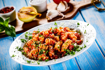 Pasta with vegetables on wooden background