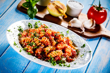 Pasta with vegetables on wooden background