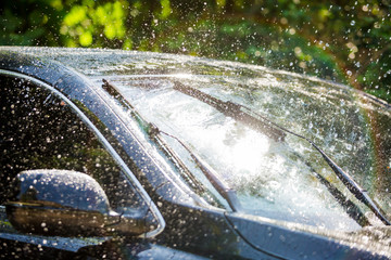 Car windshield with rain drops and frameless wiper blade - obrazy, fototapety, plakaty