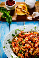 Pasta with vegetables on wooden background