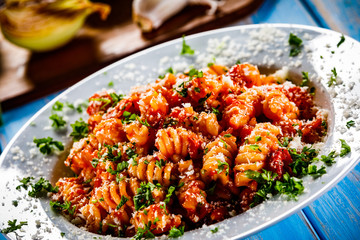 Pasta with vegetables on wooden background