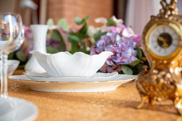 Served table with white plates on a Golden tablecloth
