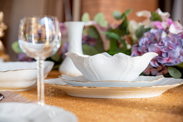 Served table with white plates on a Golden tablecloth