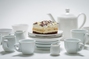 Closeup of sweet white cake with mousse, chocolate and porcelain