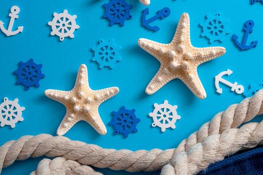 Beach vacation and seaside travel concept theme with rope, starfish, helm and anchor isolated on blue background
