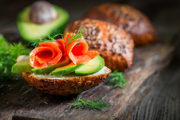 Closeup of fresh bun with avocado, dill and salmon