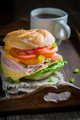 Healthy sandwich with vegetables and ham on wooden table