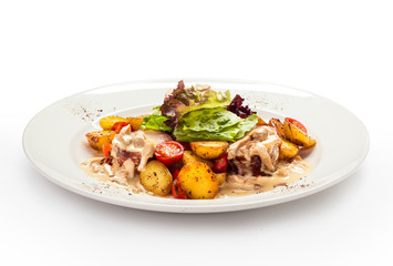 meat medallions in cream sauce with garnish of baked young potatoes
