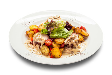 meat medallions in cream sauce with garnish of baked young potatoes