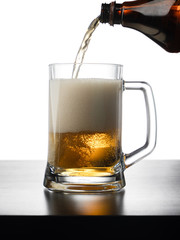 Frosty mug of light beer on wood table