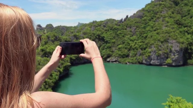Cinemagraph of Young Female Tourist Taking Photo of Emerald Lake in Angthong National Marine Park in Thailand on Mobile Phone