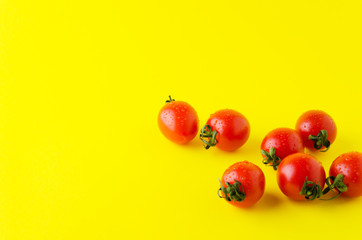 Delicious cherry tomatoes with water drops on it,yellow bright background