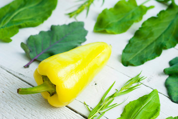 sorrel, , tarragon, turnip cabbage leaves with garlic and bell pepper on white wood background