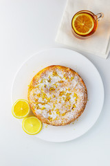 Homemade lemon pie with a cup of tea on a white wooden table