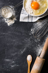 Cooking and baking utensils on black texture, vertical