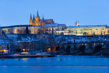 Naklejka premium Night colorful snowy Christmas Prague Lesser Town with gothic Castle and Charles Bridge, Czech republic