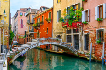 Fototapeta na wymiar Narrow canal with bridge in Venice, Italy. Architecture and landmark of Venice. Cozy cityscape of Venice.