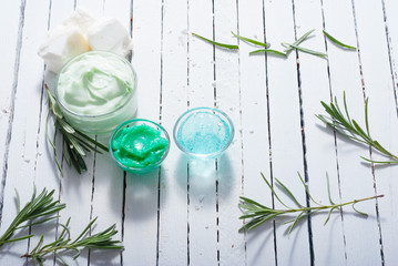 cosmetic cream product samples and lavender leaves on white wooden table background