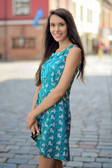 A smiling girl standing against the background of the city