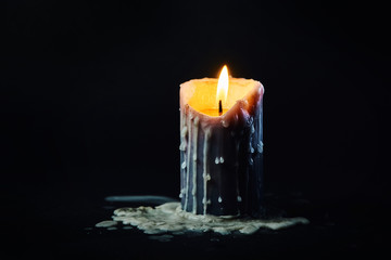 colored candle with drips of wax burns in the dark