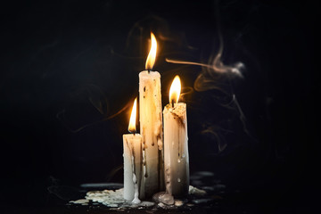 Group of white candles burning in the dark - obrazy, fototapety, plakaty