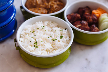 Steamed rice with parsley served in steel food carrier.